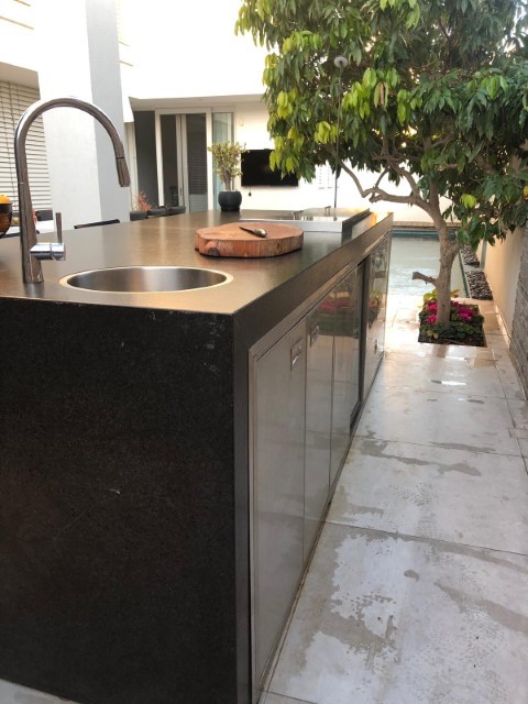 מטבח חוץ משולב בר ישיבה בחיפוי שיש גרניט. מאובזר גריל גז 9 מבערים מבית שאולי, כי מטבח חוץ משולב בר ישיבה בחיפוי שיש גרניט. מאובזר גריל גז 9 מבערים מבית שאולי, כיור מקרר וארונות אחסון